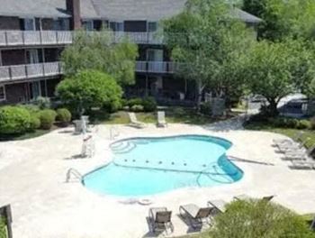 An aerial view of a swimming pool in front of an apartment building